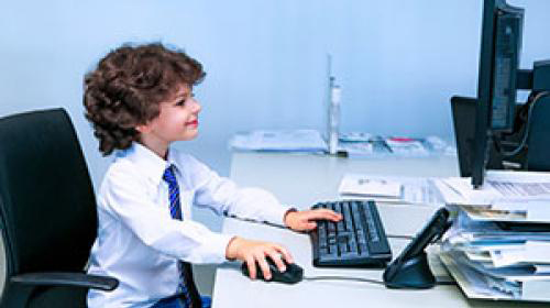 Little boy using WiFi on a computer at school