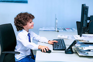 Little boy using WiFi on a computer at school